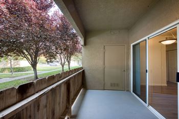 Corner Patio with sliding glass door to Living area - 4 foot fence - stucco walls and ceiling - Water heater closet